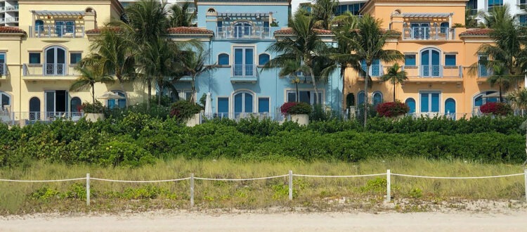 Street View of Yellow, Blue and Orange Properties in Florida with Balconies and Palm Trees