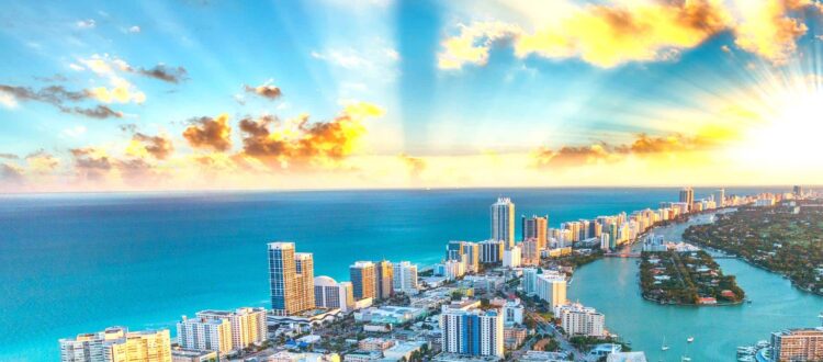 Aerial View of Miami City Buildings and Ocean with Boats at Sunrise