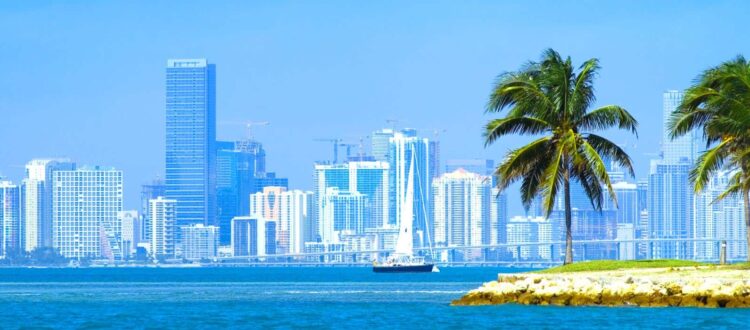 View of Miami Skyline across the Ocean with skyscrapers and a boat in the water