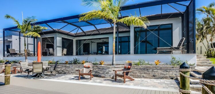 Modern and spacious outdoor space in South Florida with awning, palm trees, and several places to sit
