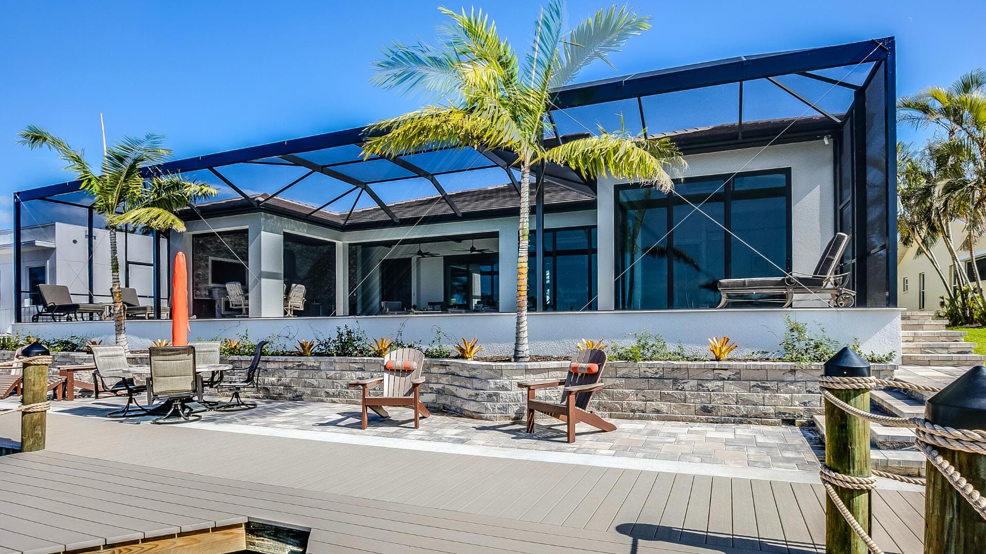 Modern and spacious outdoor space in South Florida with awning, palm trees, and several places to sit