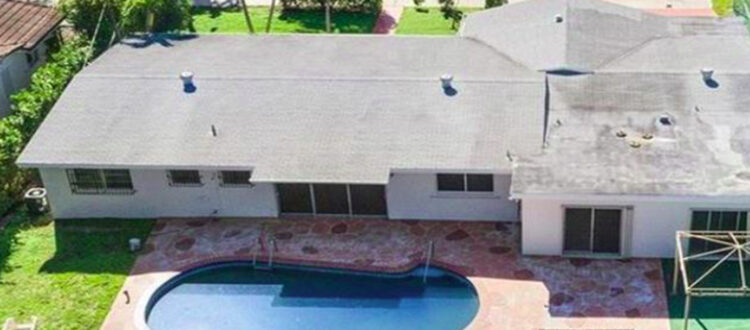 Aerial view of Residential Property with Large Backyard and Pool in Southern Florida across from a field of Palm trees