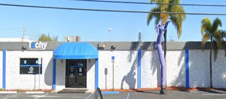 Blue and White Commercial and Manufacturing Warehouse with Large parking lot and palm trees in South Florida