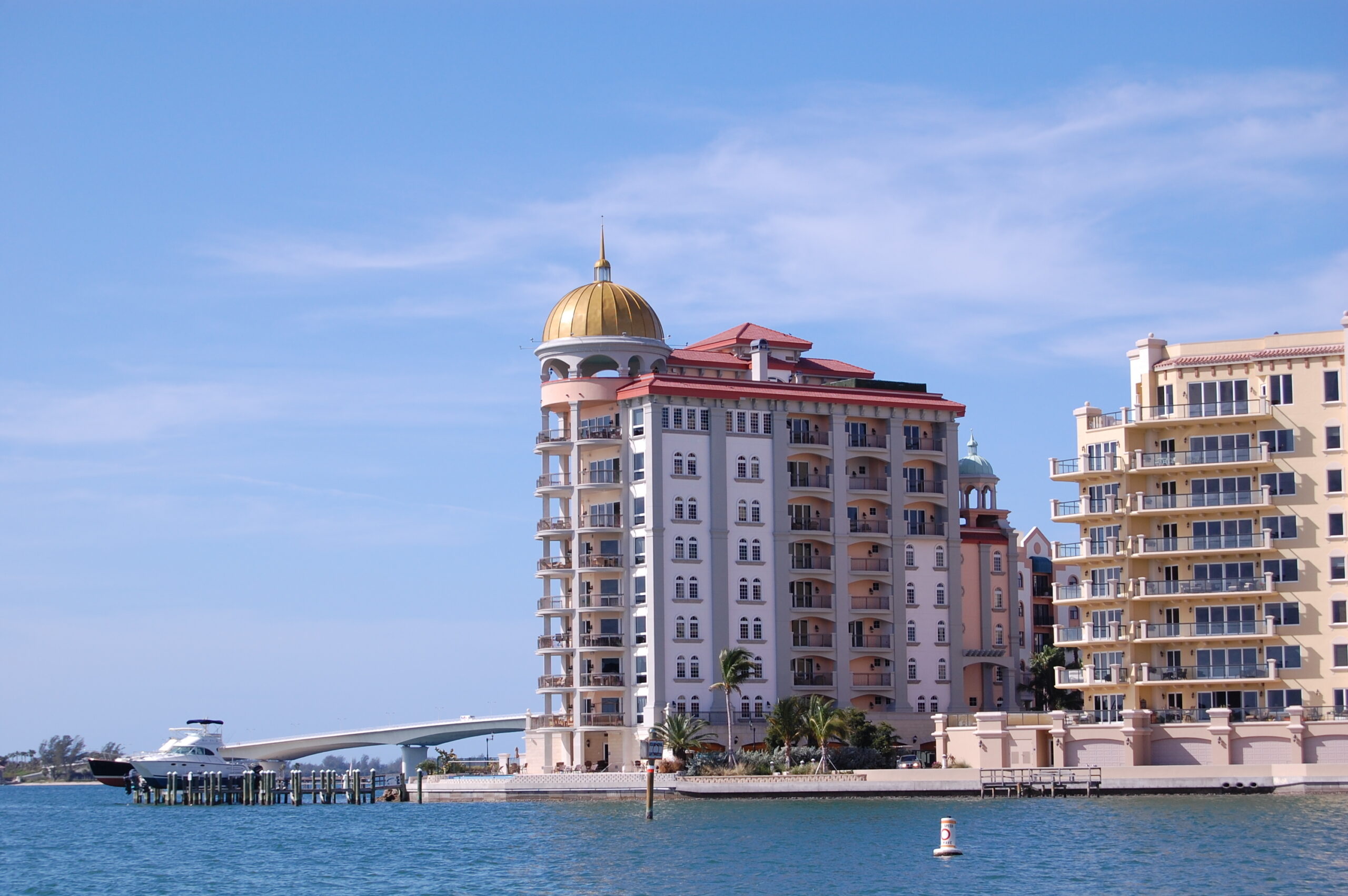Large investment condominium on Sarasota Bay, Florida, with bridge and boat in background