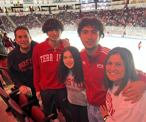 Eric Servaites and his family posing for a photo at a hockey game
