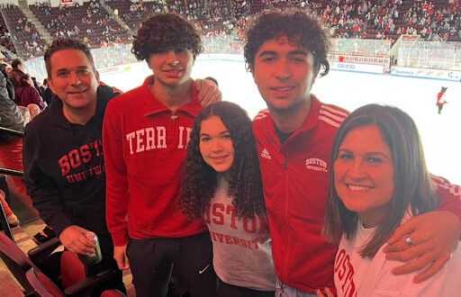 Eric Servaites and his family posing for a photo at a Boston terriers hockey game