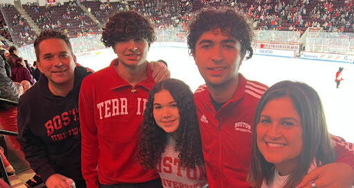 Eric Servaites and his family posing for a photo at a Boston terriers hockey game
